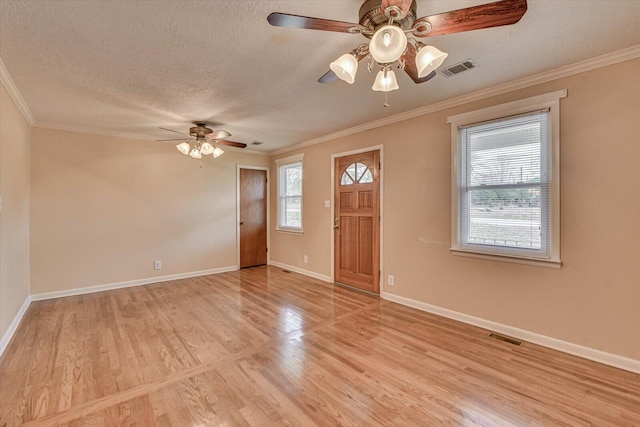 entryway with a textured ceiling, light wood-type flooring, visible vents, and crown molding