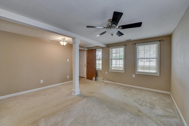 carpeted empty room featuring visible vents, a textured ceiling, baseboards, and a ceiling fan