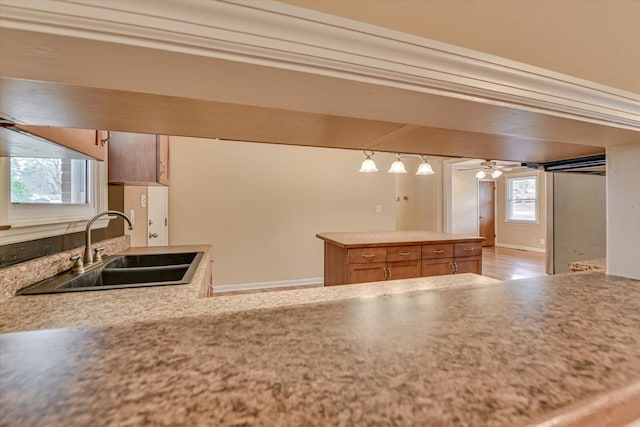 kitchen featuring light countertops, a sink, and a ceiling fan