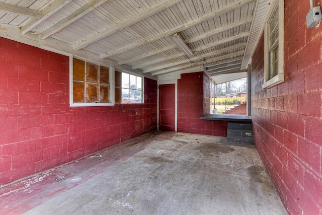 interior space featuring concrete block wall and unfinished concrete floors