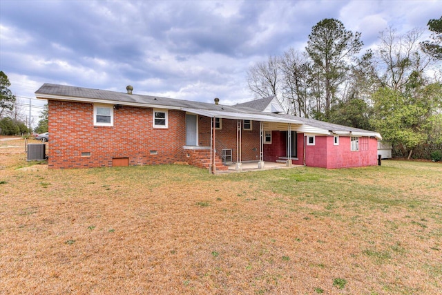 back of property featuring a patio, central air condition unit, brick siding, crawl space, and a lawn