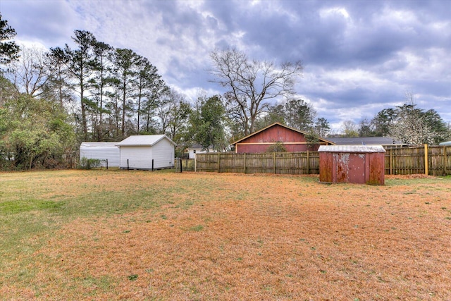 view of yard with a storage shed, an outdoor structure, and a fenced backyard