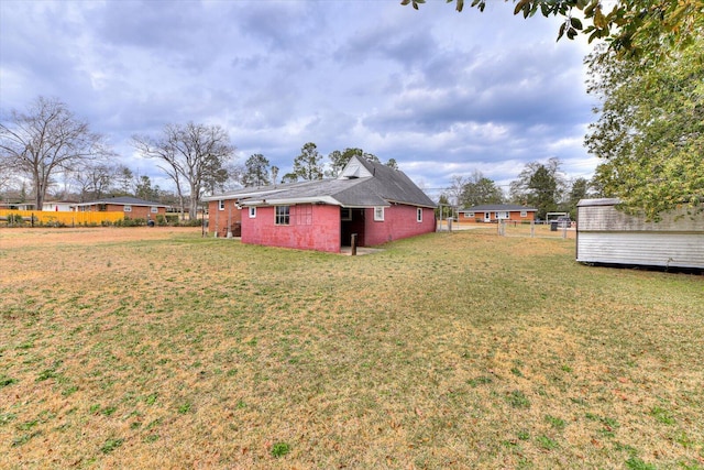 view of yard with fence and an outbuilding