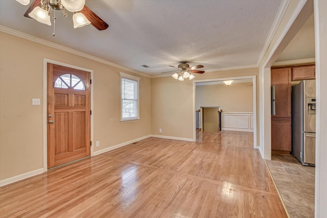 entrance foyer featuring ornamental molding, a textured ceiling, and light wood finished floors