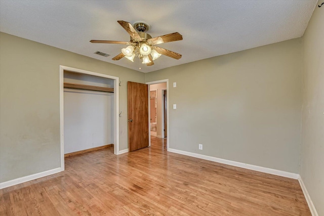 unfurnished bedroom with light wood finished floors, baseboards, visible vents, and a closet