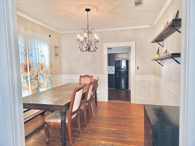 dining space featuring ornamental molding, dark wood-type flooring, and a chandelier