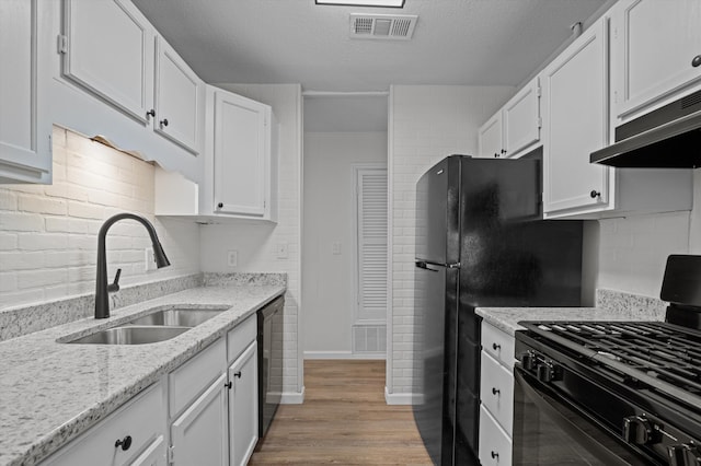 3205 E Gerald Dr, Augusta, GA 30906 - kitchen featuring gas stove, dishwasher, white cabinetry, under cabinet range hood, and a textured ceiling
