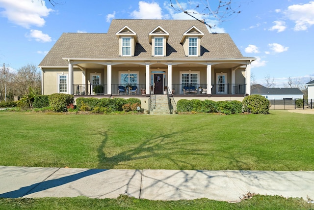 cape cod-style house featuring covered porch, a shingled roof, a front lawn, and stucco siding