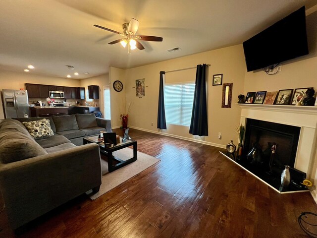 living room with ceiling fan and dark wood-type flooring