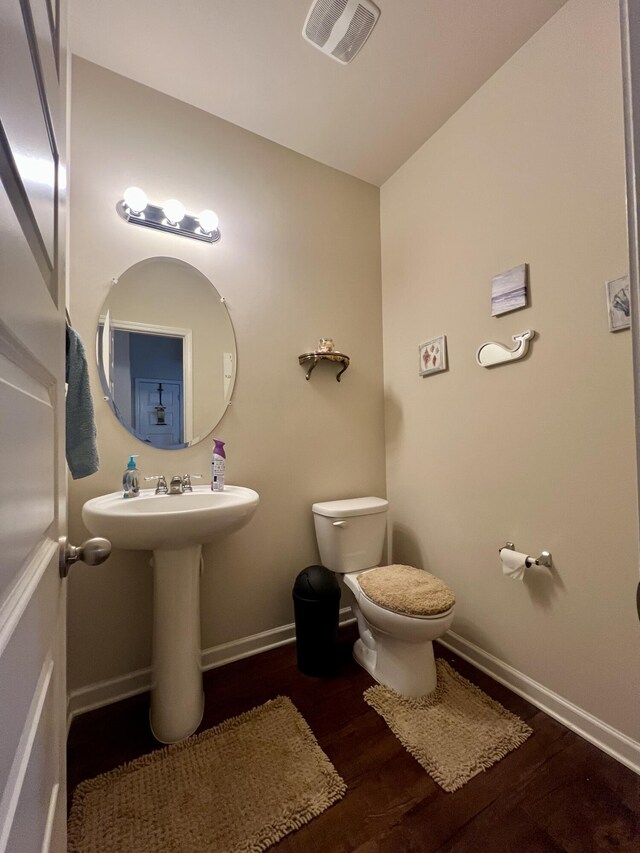 bathroom with wood-type flooring, toilet, and sink