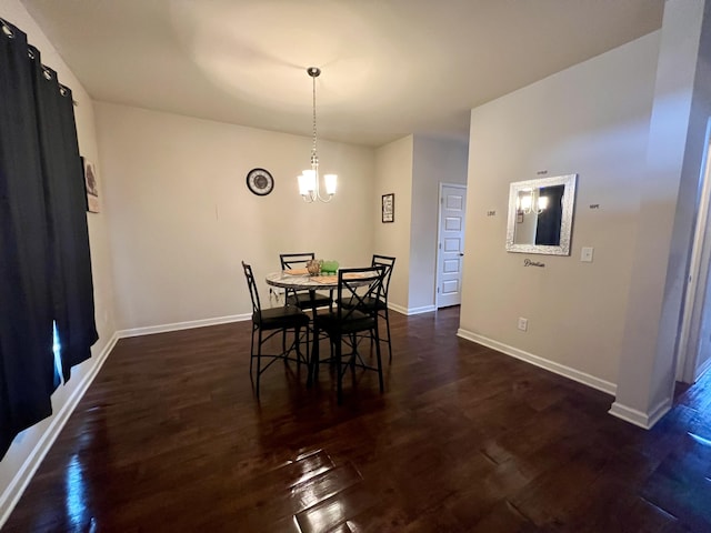 dining area featuring dark wood-type flooring and an inviting chandelier