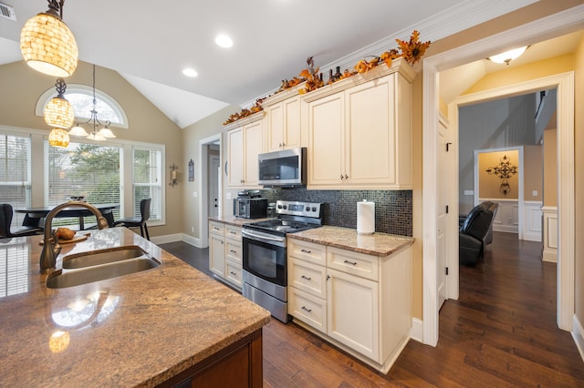 kitchen featuring visible vents, lofted ceiling, a sink, stainless steel appliances, and a notable chandelier