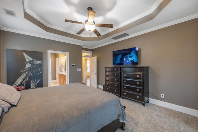 carpeted bedroom with a tray ceiling, crown molding, baseboards, and visible vents