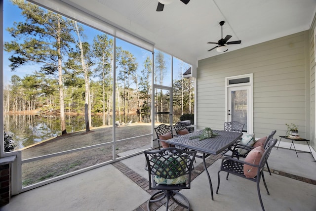 sunroom / solarium featuring a ceiling fan and a water view