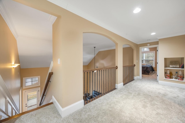 hallway featuring carpet flooring, lofted ceiling, crown molding, and baseboards