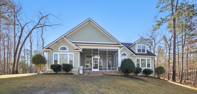 view of front of home featuring a front yard and a sunroom