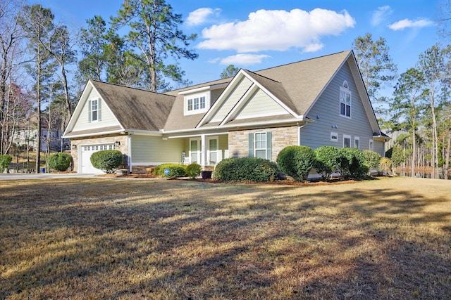 view of front facade with a front lawn, a garage, covered porch, and stone siding