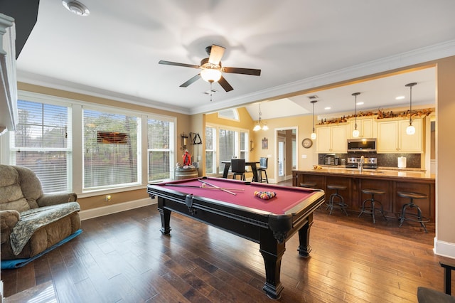 recreation room with baseboards, dark wood finished floors, a sink, vaulted ceiling, and crown molding