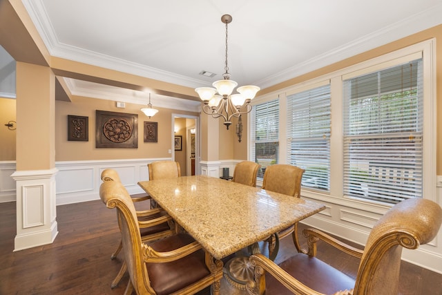 dining area featuring visible vents, ornamental molding, dark wood-style floors, decorative columns, and a chandelier