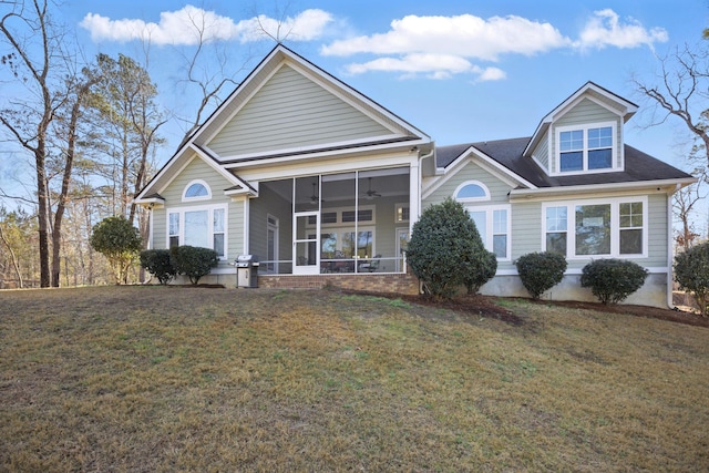 view of front facade featuring a front lawn, a ceiling fan, and a sunroom