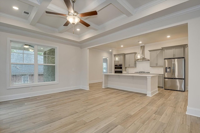 kitchen featuring coffered ceiling, stainless steel appliances, wall chimney exhaust hood, and gray cabinetry