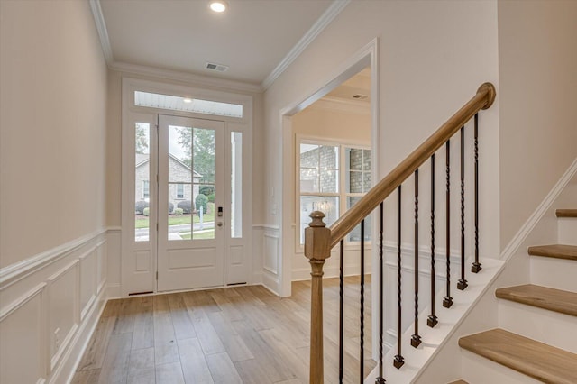 foyer featuring crown molding and light hardwood / wood-style flooring