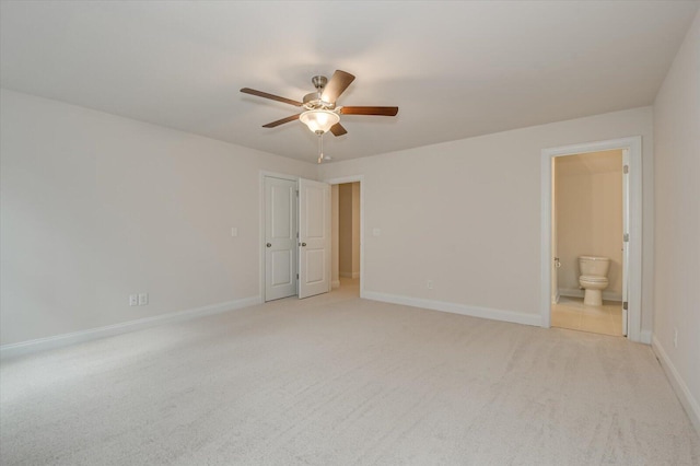 unfurnished bedroom featuring ceiling fan, ensuite bathroom, and light carpet