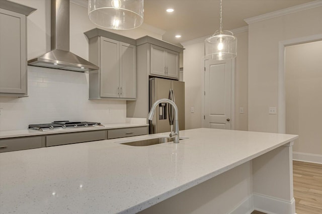 kitchen with wall chimney exhaust hood, gray cabinets, ornamental molding, light stone counters, and stainless steel appliances