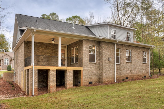 rear view of property featuring ceiling fan and a lawn