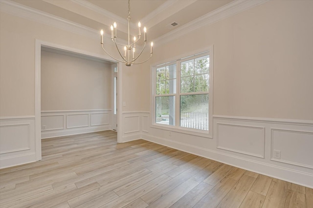 unfurnished dining area featuring ornamental molding, light wood-type flooring, and a notable chandelier