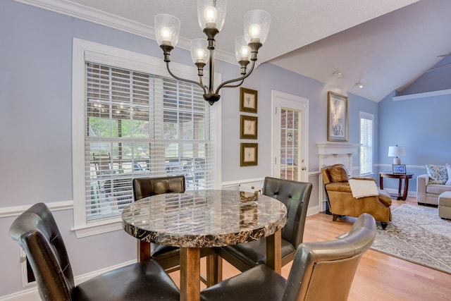 79 Loggerhead Dr, Columbia, SC 29229 - dining room featuring wood finished floors, a chandelier, vaulted ceiling, crown molding, and a fireplace