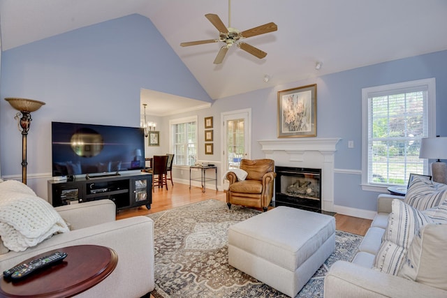 79 Loggerhead Dr, Columbia, SC 29229 - living room with wood finished floors, a glass covered fireplace, a ceiling fan, a chandelier, and high vaulted ceiling