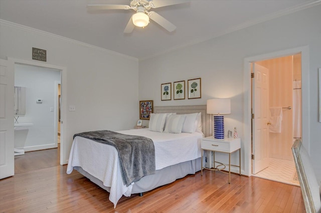 bedroom featuring ornamental molding, ensuite bathroom, ceiling fan, and hardwood / wood-style floors