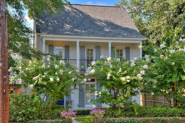 view of front of house featuring stucco siding, fence, and a shingled roof