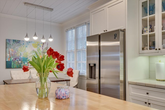 kitchen with white cabinetry, glass insert cabinets, stainless steel refrigerator with ice dispenser, and ornamental molding