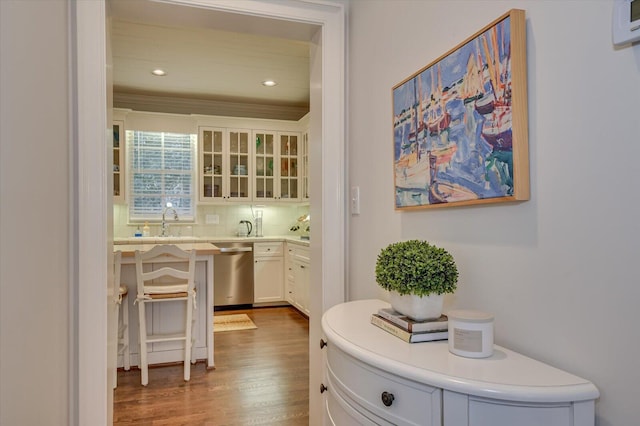 bar with recessed lighting, a sink, dark wood-type flooring, dishwasher, and tasteful backsplash