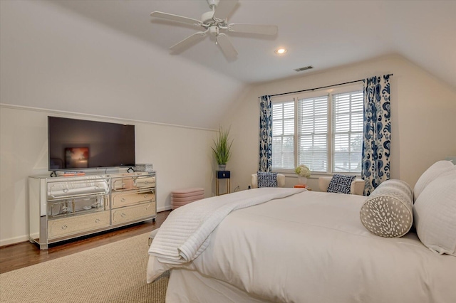 bedroom featuring vaulted ceiling, wood finished floors, visible vents, and baseboards