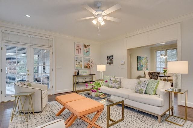 living area with wood finished floors, baseboards, french doors, crown molding, and ceiling fan with notable chandelier