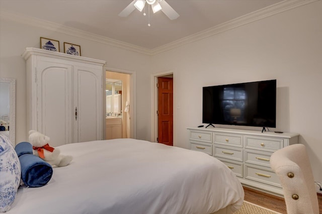 bedroom featuring connected bathroom, a ceiling fan, wood finished floors, and crown molding