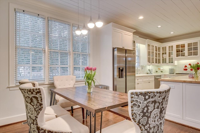 dining space with recessed lighting, light wood-style flooring, wooden ceiling, and ornamental molding