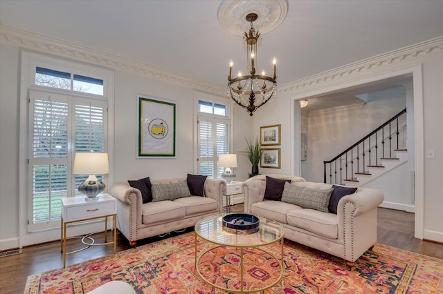 living room featuring a notable chandelier, plenty of natural light, stairs, and ornamental molding