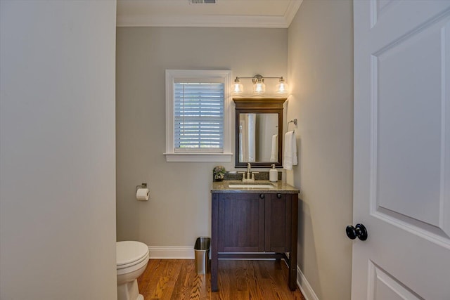 bathroom with hardwood / wood-style flooring, vanity, toilet, and ornamental molding