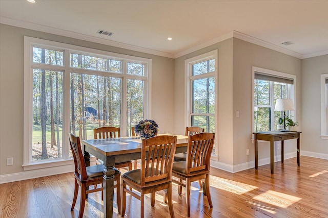 dining area featuring light hardwood / wood-style flooring and ornamental molding