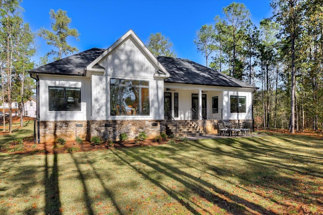 view of front of house with ceiling fan and a front yard