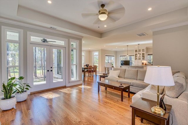 living room featuring ceiling fan, french doors, and a healthy amount of sunlight