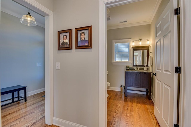 bathroom featuring crown molding, vanity, wood-type flooring, and toilet