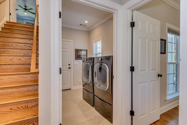 washroom featuring light wood-type flooring, separate washer and dryer, ceiling fan, and ornamental molding