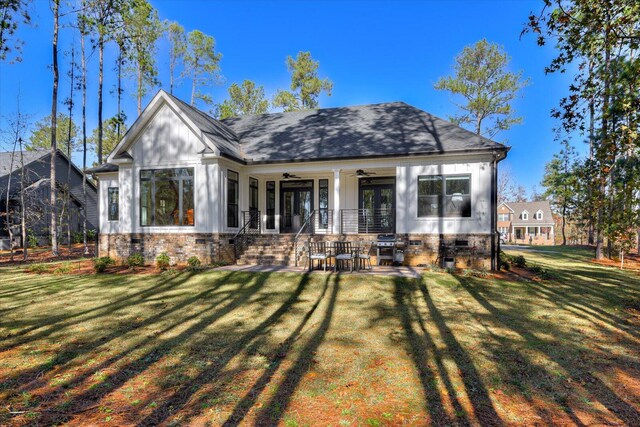 back of property featuring a lawn, ceiling fan, and a porch