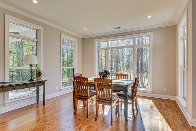 dining room with light hardwood / wood-style flooring, plenty of natural light, and crown molding