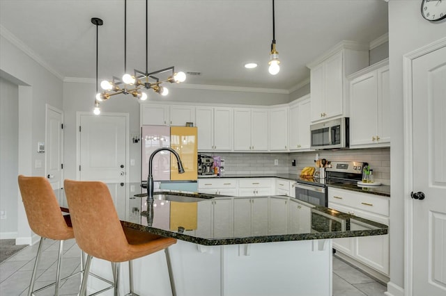 kitchen with stainless steel appliances, sink, an island with sink, and white cabinets